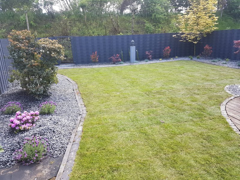 Neu angelegter Garten mit Rollrasen, Beeteinfassung und Sichtschutzzaun in Essen