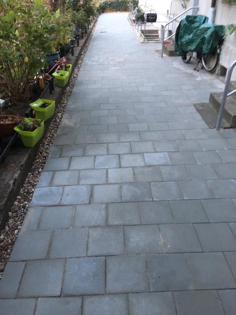 Neu gepflasterter Gehweg mit dunklen Pflastersteinen in Essen